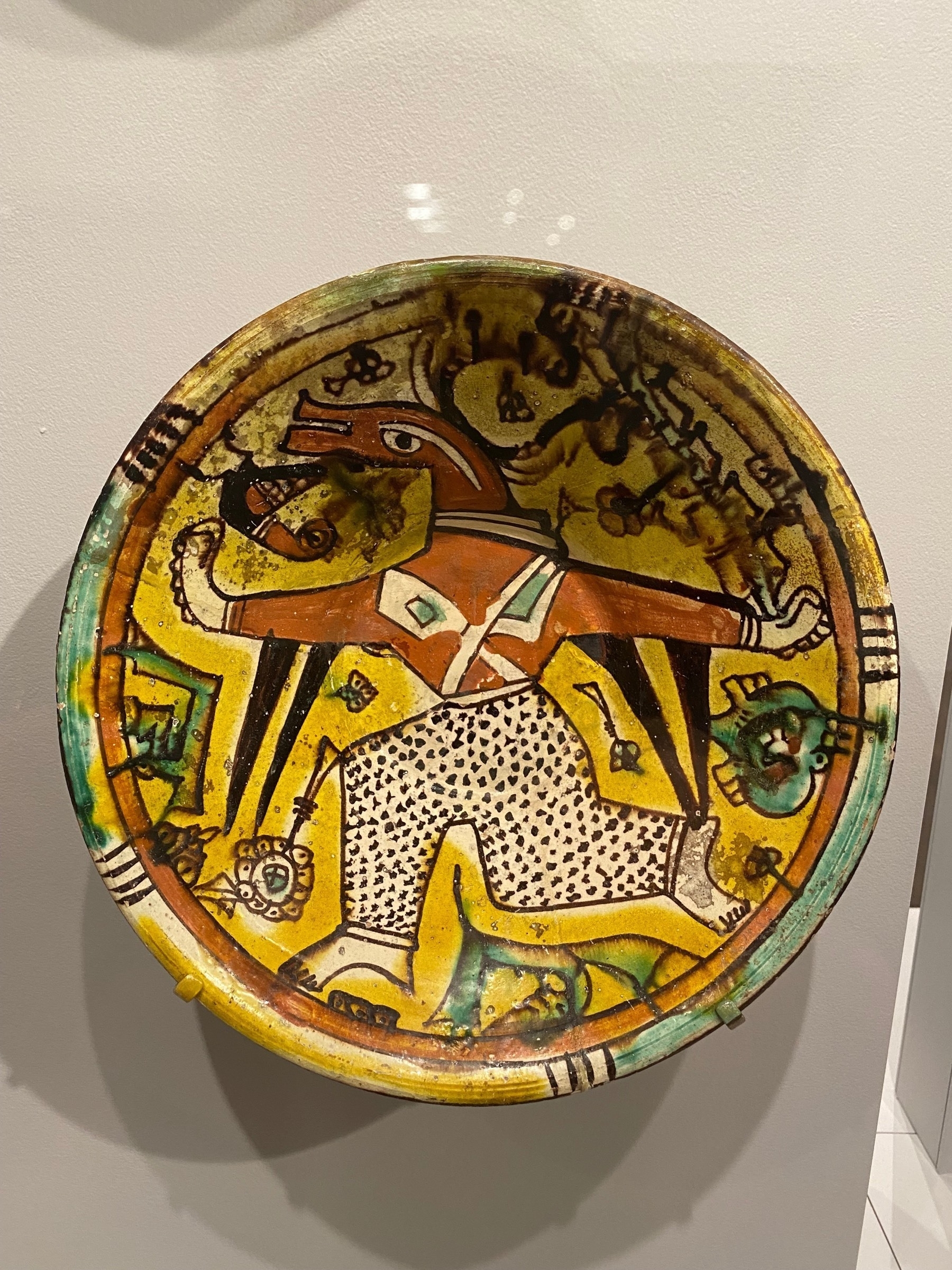 Top view of a yellow bowl with the figure of a dancer wearing polka-dot pants.